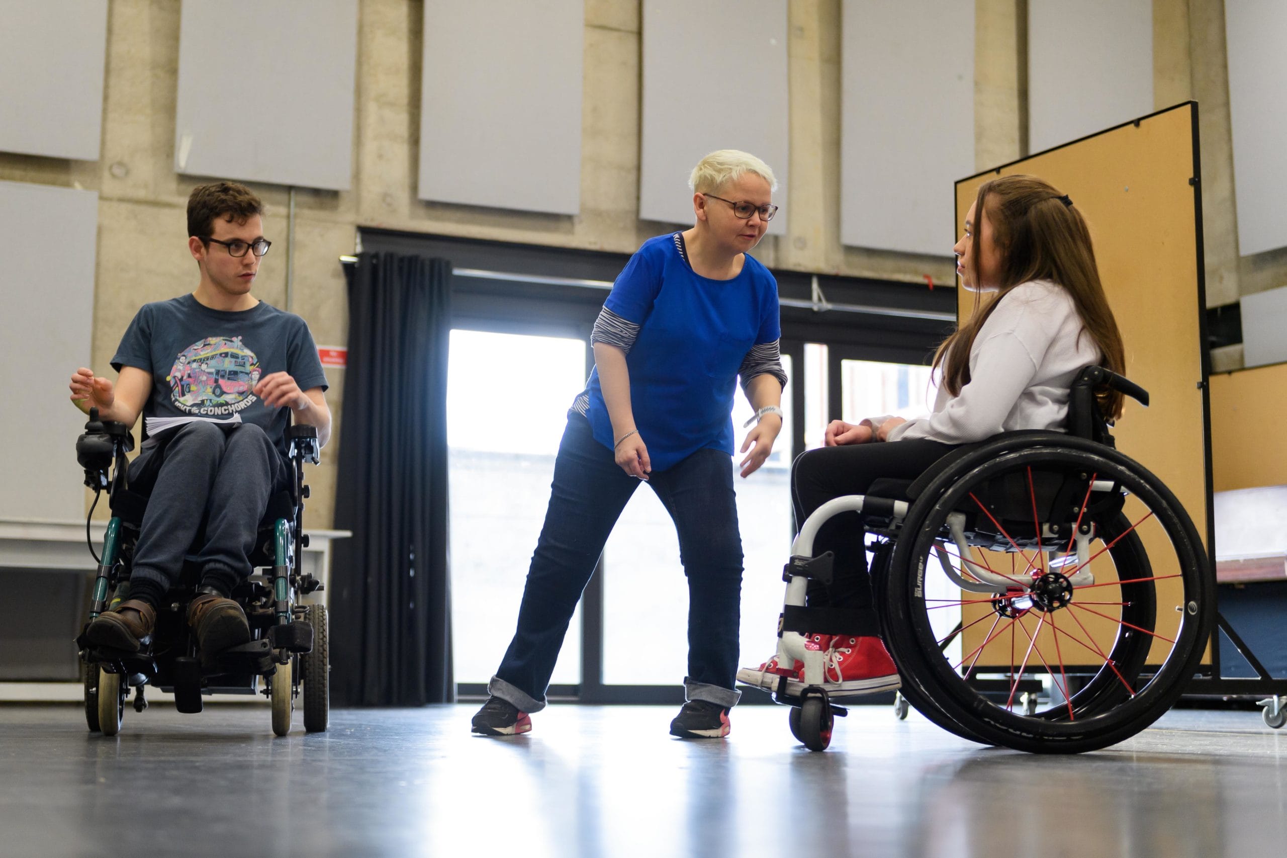 Rehearsals for Kerbs, Maya Coates and Jack Hunter face each other whilst a woman in between them watches.