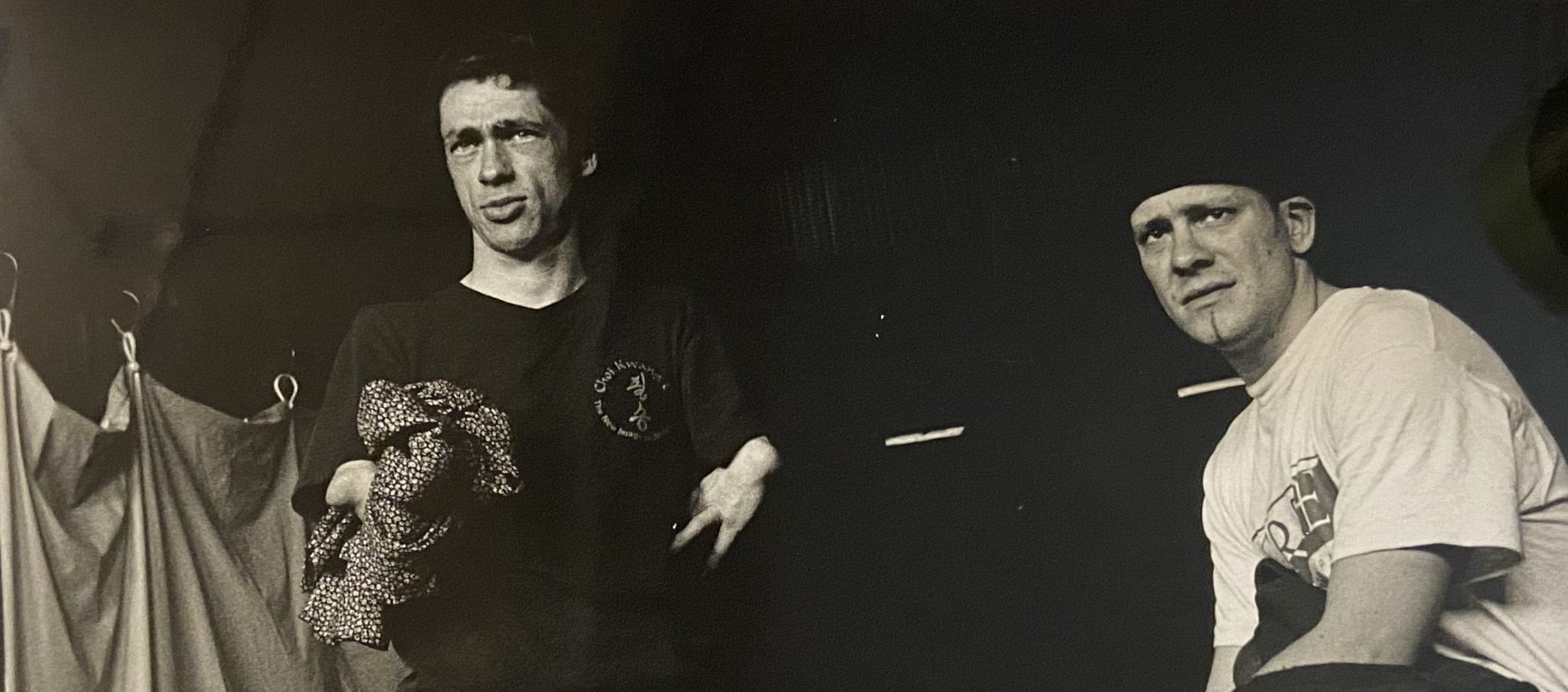 Black and white photo of two actors onstage. Mat Fraser is on the left side, next to him is another actor.