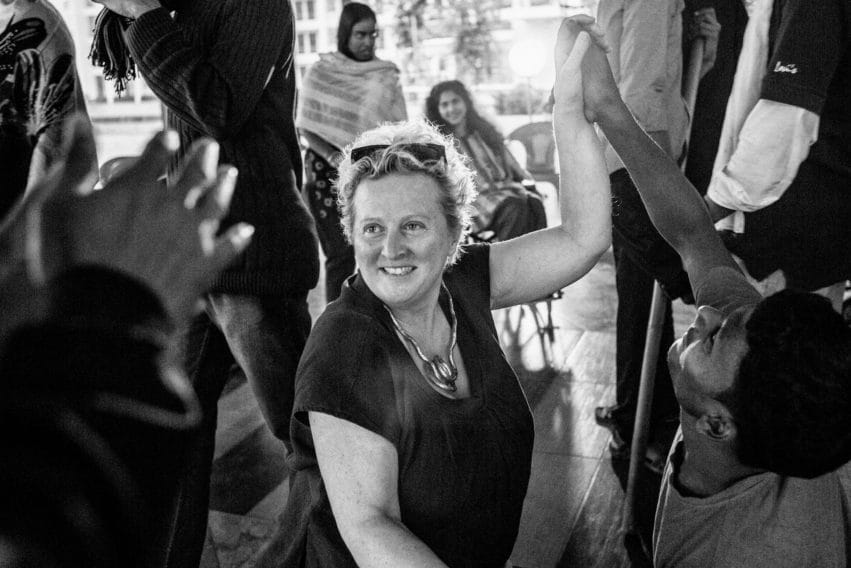 Jenny Sealey holds hands with a young man and smiles.