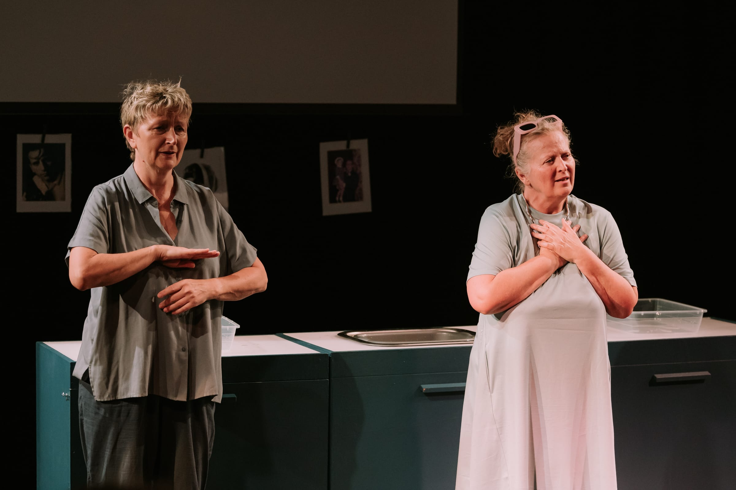 Two women onstage, one woman is signing while the other acts.