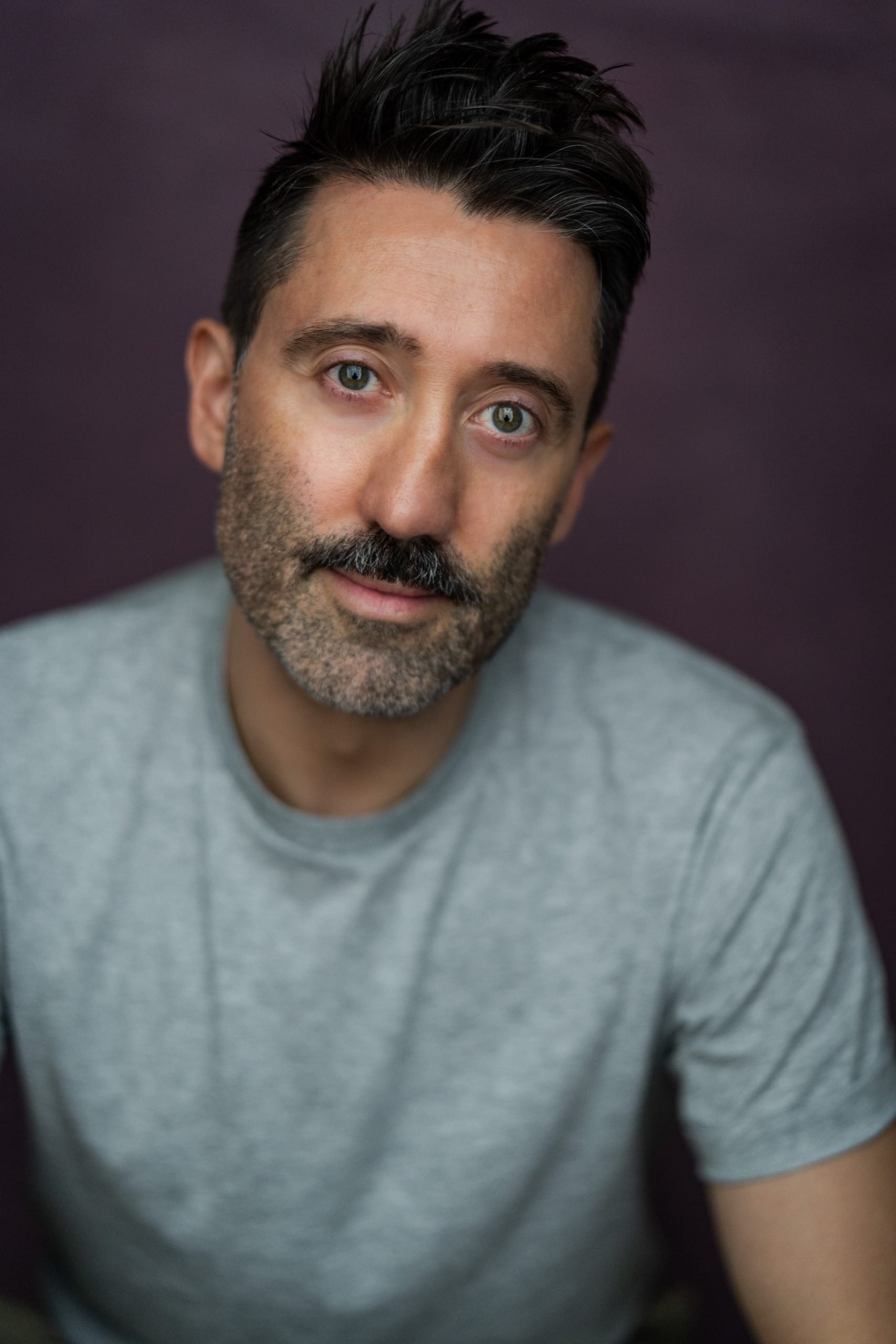 A white man with short dark hair and a moustache.