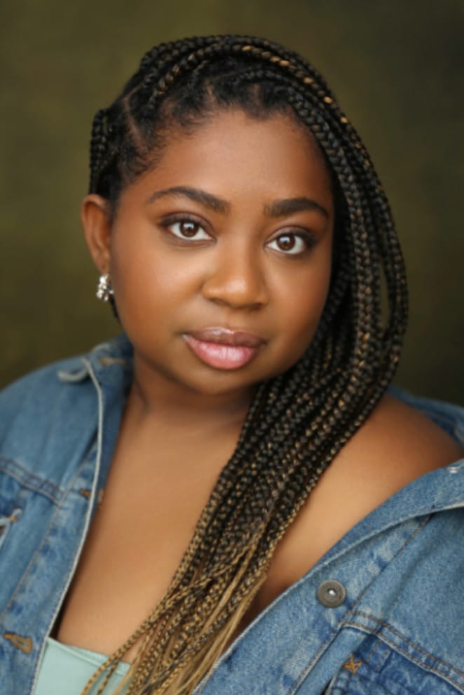 A woman of colour wearing a denim shirt. She has long dark braids. Name: Cherie Gordon.