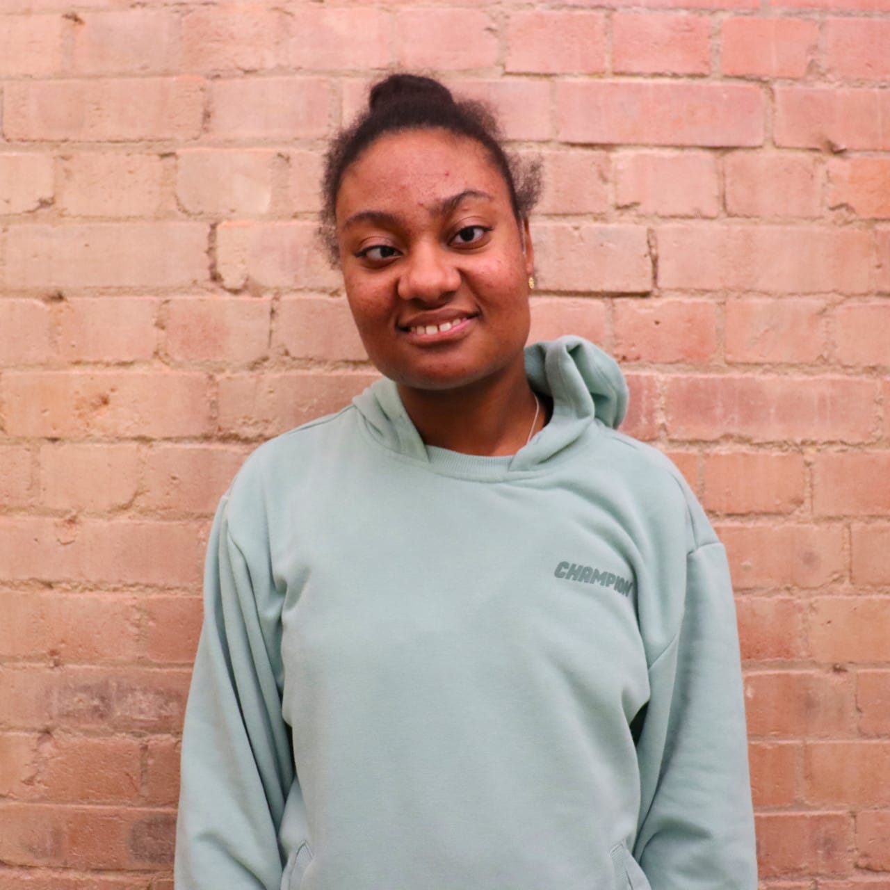 A woman smiling. wearing a light green jumper