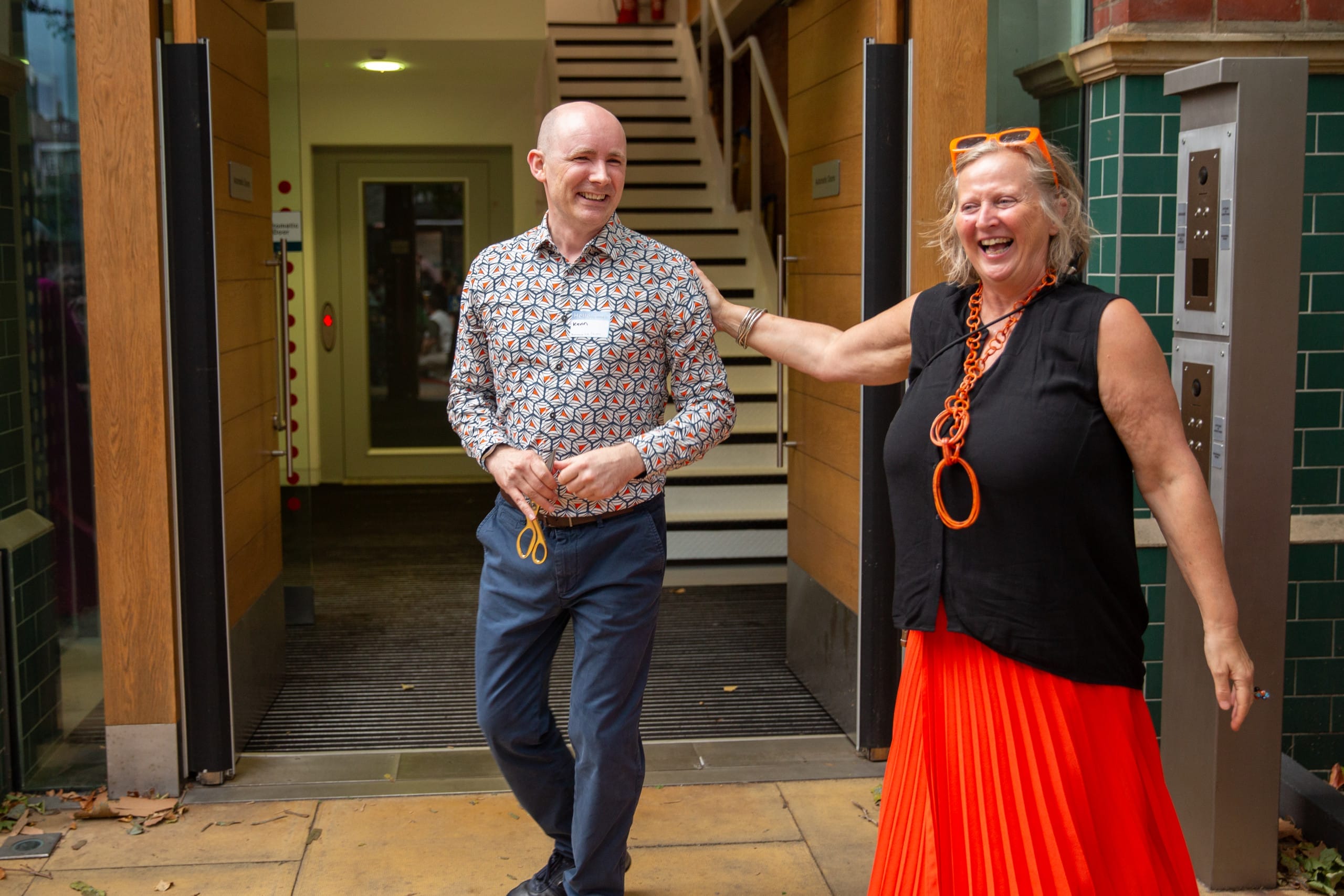 Jenny Sealey and Kevin Walsh smiling and laughing as they open the Graeae building