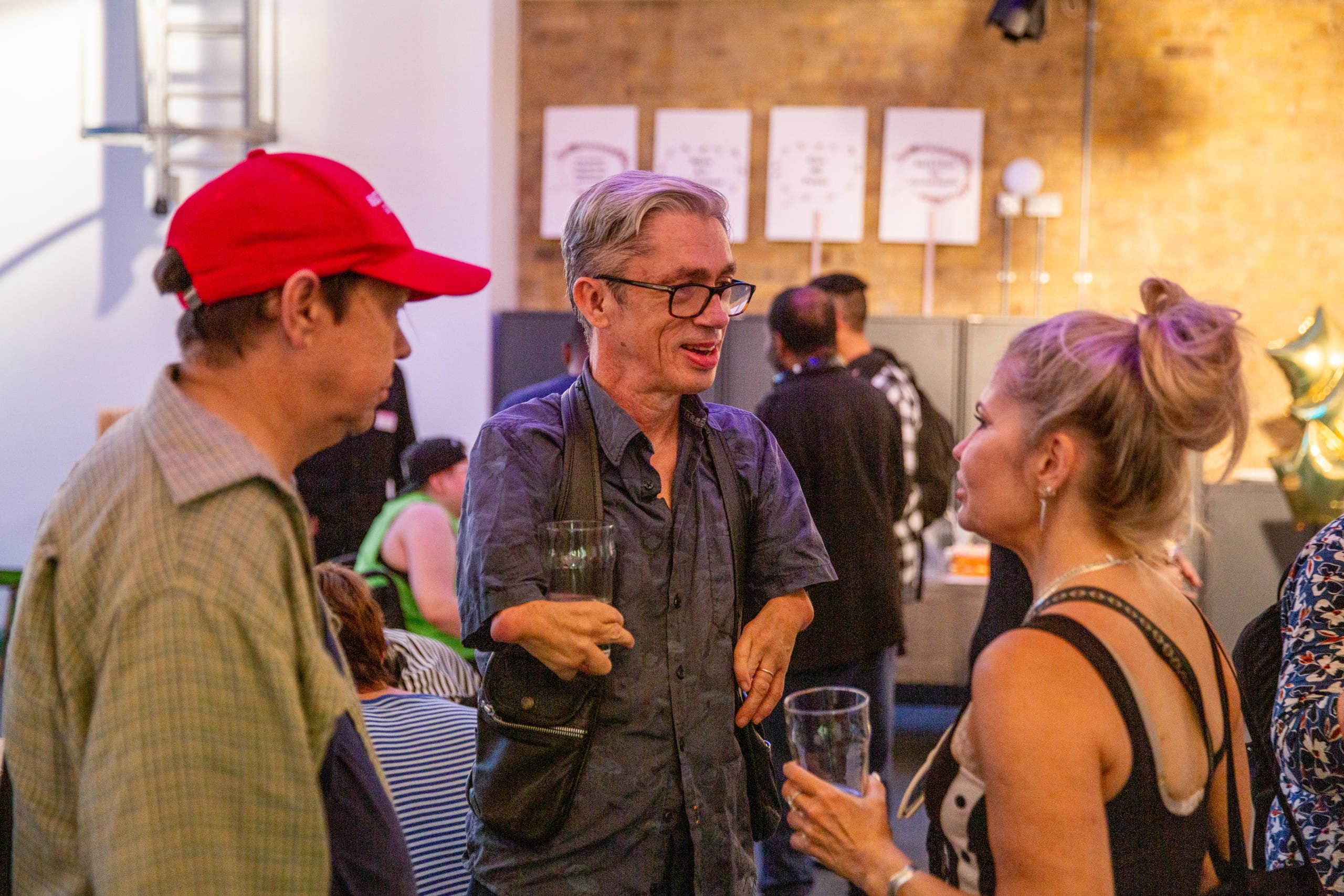 Mat Fraser talking to two people at Graeae
