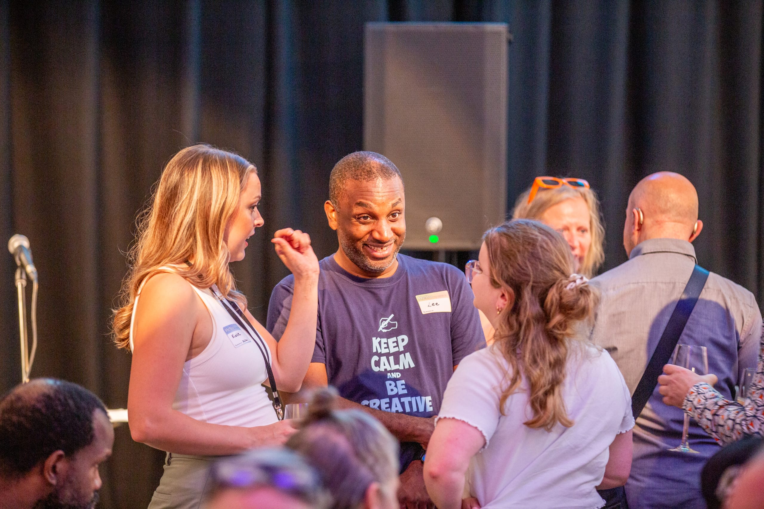 A group of people talking and smiling in Graeae's rehearsal room