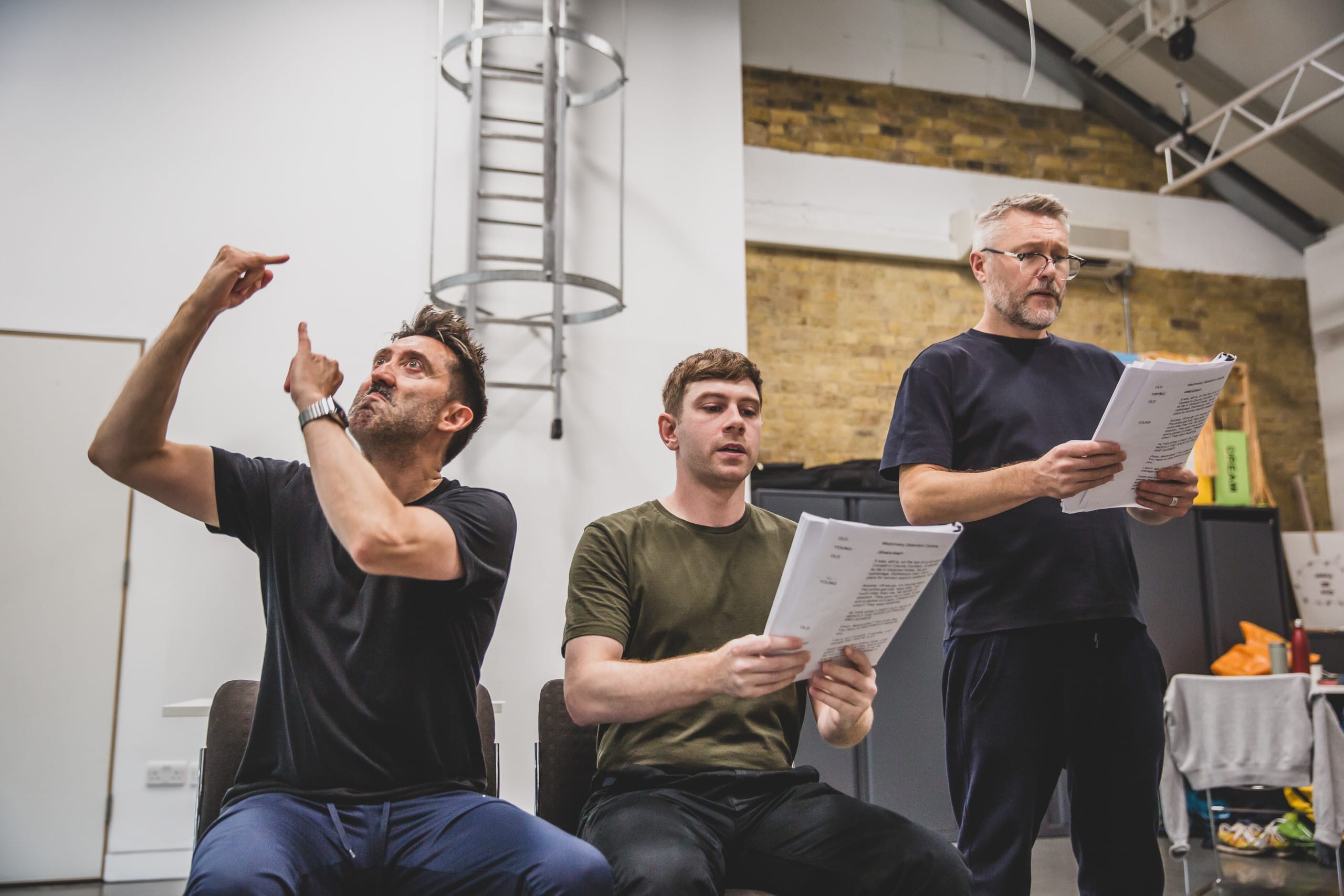 Cast members Craig Paining, Danny Raynor and Robin Paley Yorke in a line with script in hand. Craig is signing.